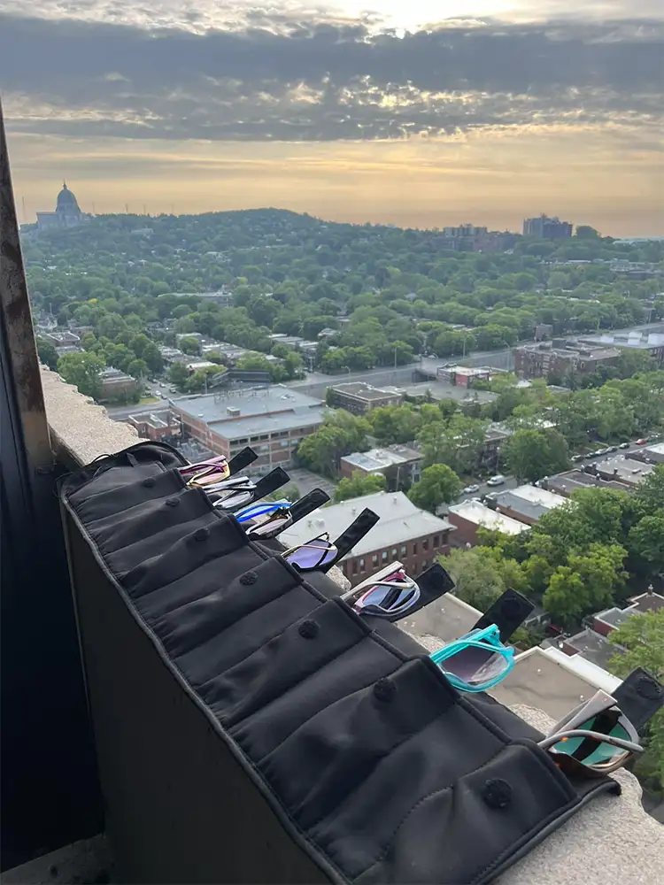FTG eyewear organizer holding multiple glasses during travel overlooking city skyline