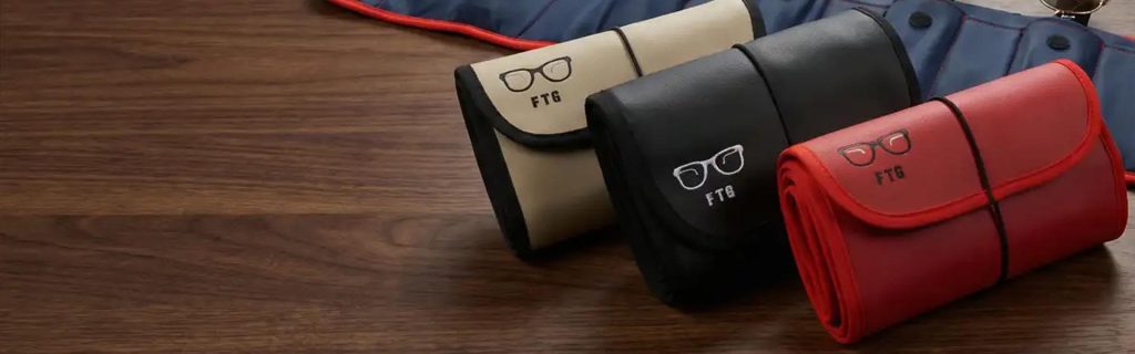 FTG eyewear organizer collection in vegan leather on wooden table, designed by Suzanne Sendel to carry multiple glasses while traveling.